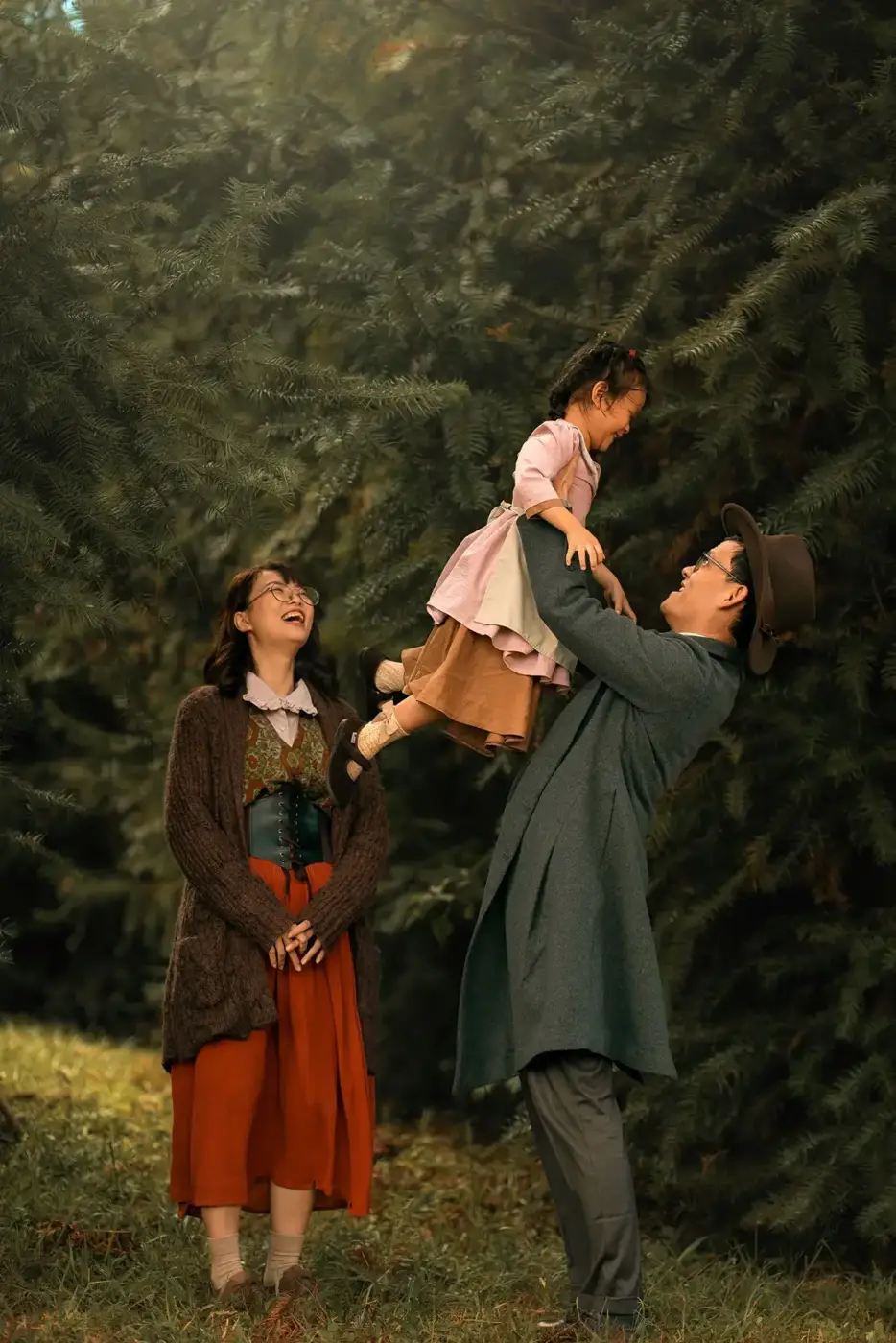 Family outdoors among evergreen trees